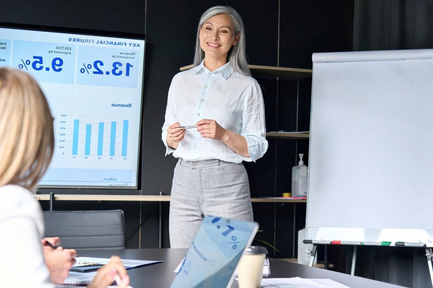 Businesswoman presenting quarterly figures on a rented screen during a Dubai corporate meeting