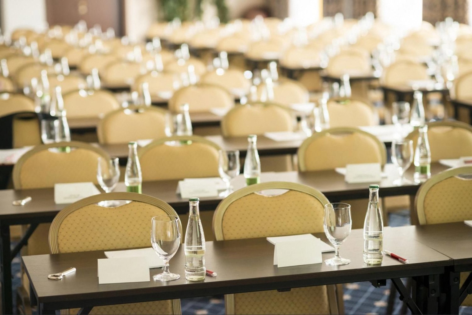 Rows of conference chairs and tables set up for a corporate event in a Dubai hotel ballroom